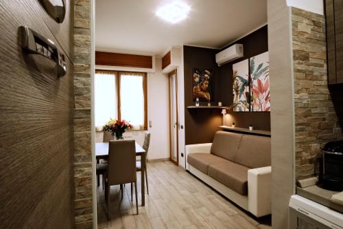 a living room and dining room with a couch and a table at Appartamento a due passi dal mare in Bordighera
