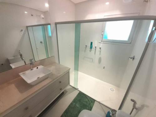 W łazience znajduje się umywalka i przeszklony prysznic. w obiekcie Casa de Campo em meio a Vinhedos w mieście Pinto Bandeira