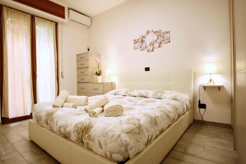 a white bedroom with a large bed with pillows at Appartamento a due passi dal mare in Bordighera