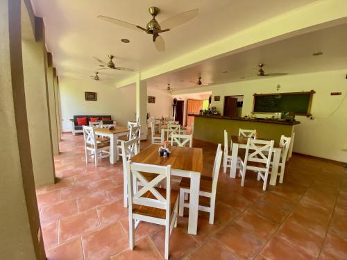 a dining room with tables and white chairs at Rio Tico Safari Lodge in Punta Mala