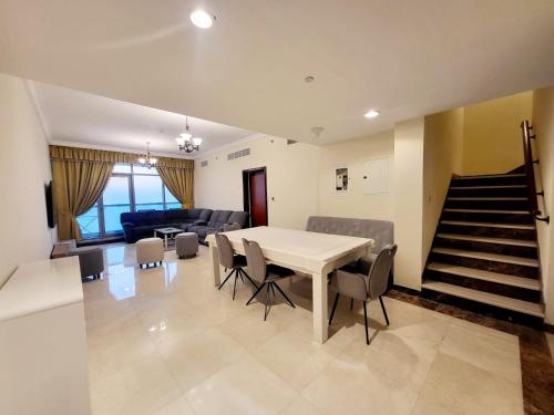 Beachfront Holiday Homes في عجمان: غرفة طعام وغرفة معيشة مع طاولة وكراسي