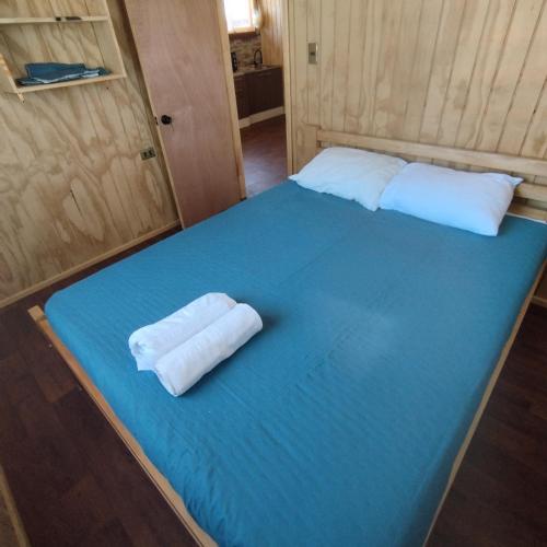 a bed in a room with two pillows on it at Cabañas altos de la chacra , 2 dormitorios in Castro