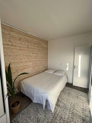 une chambre avec un lit et un mur de briques dans l'établissement Paris flat, à Malakoff