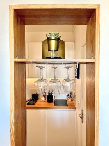 d'une armoire avec des verres à vin et un pot sur le dessus dans l'établissement Paris flat, à Malakoff