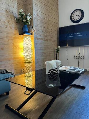 un salon avec une table en verre et une horloge dans l'établissement Paris flat, à Malakoff