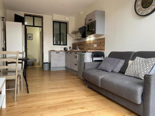 a living room with a couch and a kitchen at Lyon Standing Historic City Apartment in Lyon
