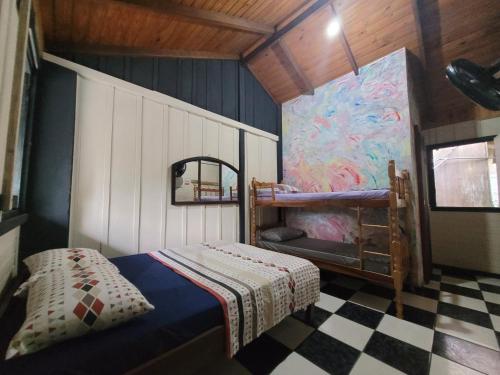 um quarto com um beliche e um piso em xadrez em Pousada e Camping do Clodo na Ilha do Mel