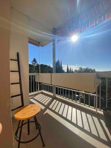 a balcony with a chair and a table on a balcony at Cocon ensoleillé avec parking gratuit in Nice
