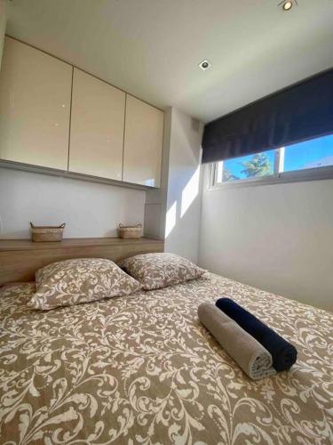a bedroom with a bed with two pillows and a window at Cocon ensoleillé avec parking gratuit in Nice