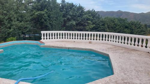 una piscina en un patio con una valla blanca en Cabaña del mirador in 