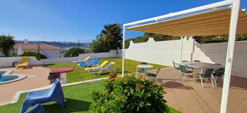 eine Terrasse mit einem Tisch, Stühlen und einem Sonnenschirm in der Unterkunft Villa Ramos in Albufeira