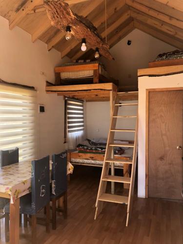 a room with a bunk bed and a desk and a ladder at Vista Mahuida casa 2 in Icalma
