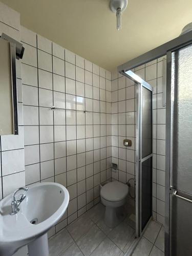 a bathroom with a toilet and a sink at Residencial Copacabana in Guarapari