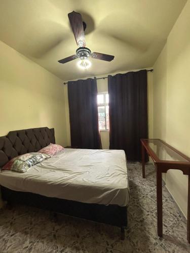 1 dormitorio con 1 cama y ventilador de techo en Residencial Copacabana en Guarapari