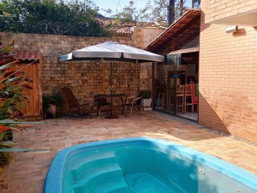 a swimming pool with an umbrella and a patio at Casa Sobrado com piscina Santa Felicidade 6 pessoa in Curitiba