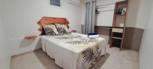 a bedroom with a bed with a wooden headboard at Appartement cosy in Fort-de-France