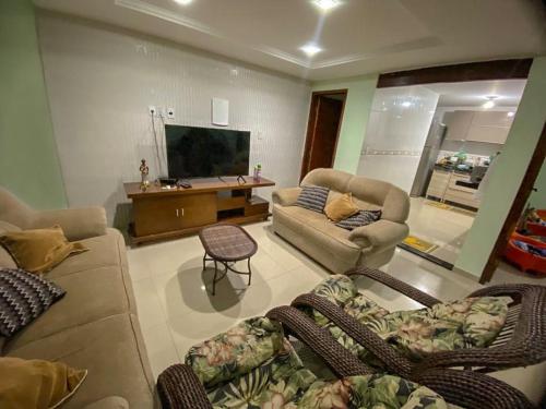 ein Wohnzimmer mit Sofas und einem Flachbild-TV in der Unterkunft Casa Paraíso Costeiro in Iguaba Grande