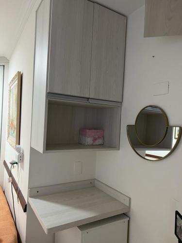 a kitchen with a sink and a mirror on a wall at Quarto privativo em casa domiciliar in Campo Grande