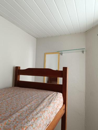 Dormitorio pequeño con cama y espejo en Duplex com dois Quartos, en Salvador