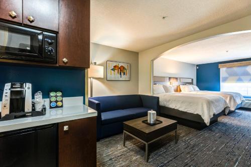 une chambre d'hôtel avec un lit et un canapé dans l'établissement Holiday Inn Express Hotel & Suites Salina, an IHG Hotel, à Salina