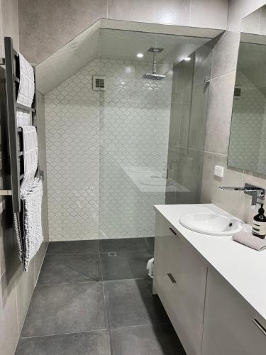 a bathroom with a glass shower and a sink at Inner City Pad in Ballarat