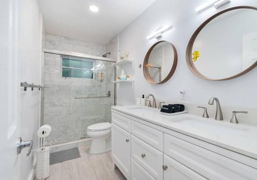 a bathroom with a sink and a toilet and a mirror at Summer By The Sea 2 in Pompano Beach