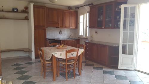 een keuken met een tafel en stoelen en een keuken met houten kasten bij Casa Leoni Capoliveri Isola d'Elba in Capoliveri