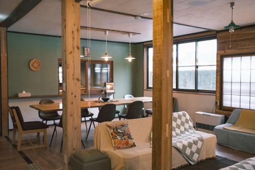 a living room with a table and a dining room at The Greenhouse in Myoko