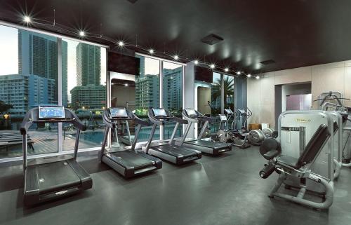a gym with a bunch of exercise equipment in a building at MVR Apartments at Beachwalk Resort in Hallandale Beach