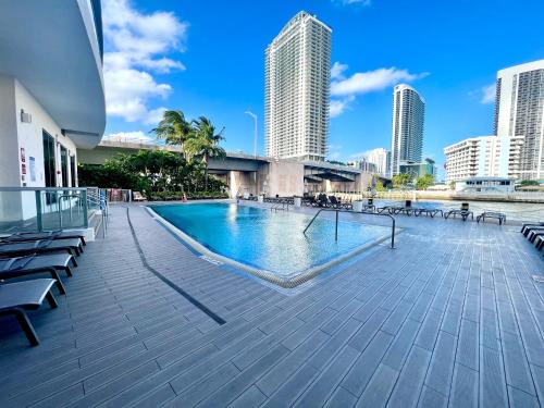 a swimming pool in the middle of a city with tall buildings at MVR Apartments at Beachwalk Resort in Hallandale Beach