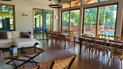 a living room with a couch and tables and chairs at Departamento Pucon Condominio Alicura in Pucón