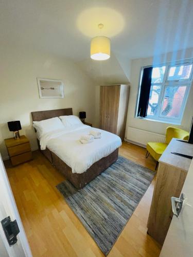 a bedroom with a large bed and a window at Baravaggio By Kasar Stays in Leicester
