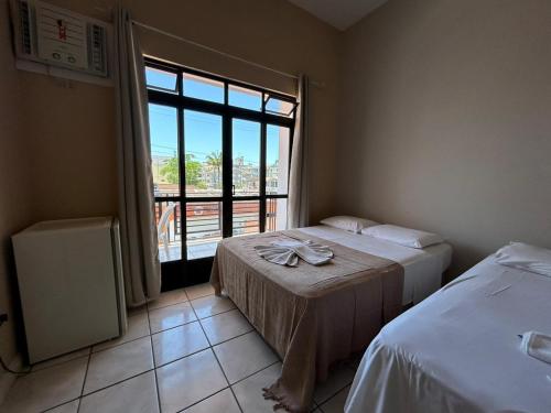a bedroom with two beds and a large window at Ilha azul hospedagem in Florianópolis