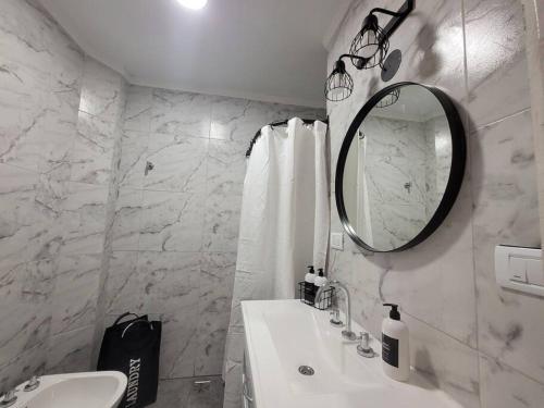 a white bathroom with a sink and a mirror at Sueño Maipú in Mar del Plata