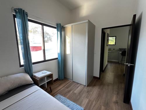 um quarto com uma cama e uma porta para uma casa de banho em Peaceful Apartment by the Langosta Beach em Tamarindo
