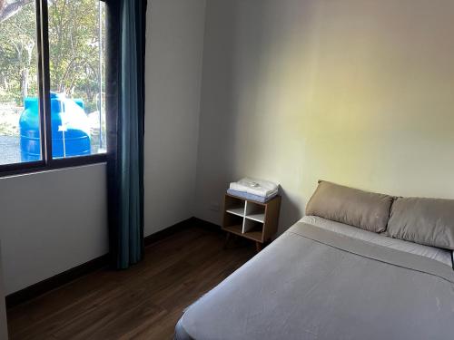 a small room with a bed and a window at Peaceful Apartment in Tamarindo, 50m to the Beach - Sofia Apartments in Tamarindo