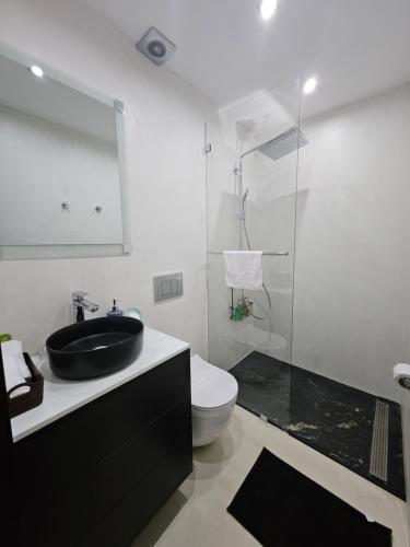 a bathroom with a black sink and a toilet at Urbanizacion privada "El Sol", Villa K2 in Machala