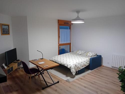 une chambre avec un lit, un bureau et une table dans l'établissement L'EDEN DE CHARTRES, à Chartres