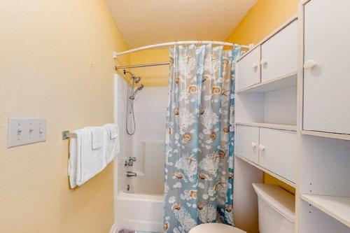 a bathroom with a shower with a blue shower curtain at Ocean City Townhome by Beach Bayside in Ocean City