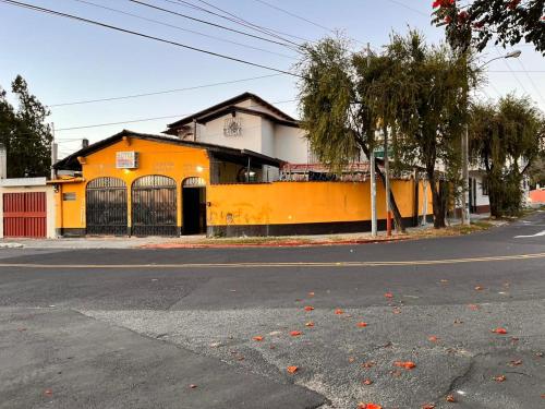 un edificio naranja al lado de una calle en Hotel Canaan La aurora, en Guatemala