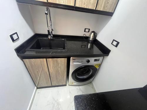 a small kitchen with a sink and a washing machine at Nice apartment 3 in Cairo
