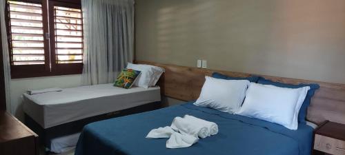 ein Schlafzimmer mit 2 Betten und Handtüchern darauf in der Unterkunft Apartamento PIPA - UF01 dentro de Condominio Pipa Park in Pipa