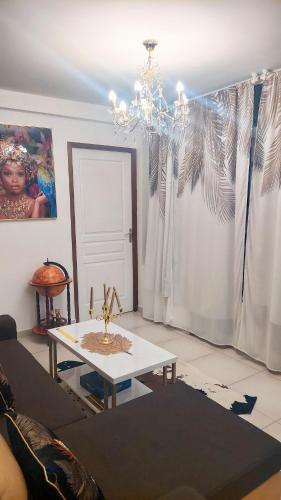 a living room with a chandelier and a table at Dolce Pace Kreyol in Cayenne