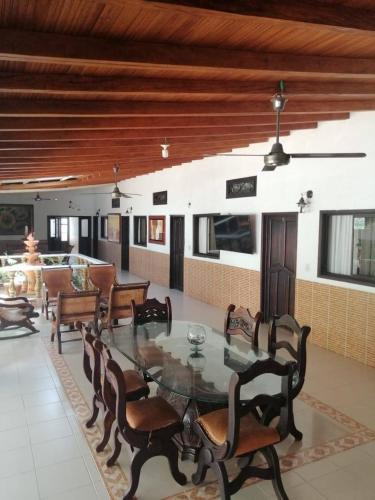 een eetkamer met een glazen tafel en stoelen bij Hotel Casablanca de Santodomingo in Aguachica