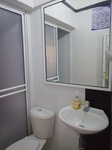 La salle de bains est pourvue de toilettes, d'un lavabo et d'un miroir. dans l'établissement Hotel Casablanca de Santodomingo, à Aguachica