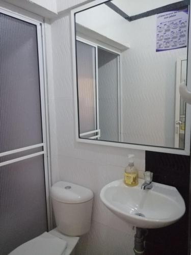 a bathroom with a toilet and a sink and a mirror at Hotel Casablanca de Santodomingo in Aguachica