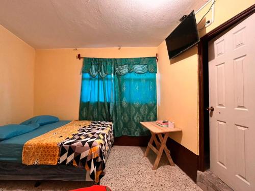 Habitación pequeña con cama y ventana en Hotel Canaan La aurora, en Guatemala