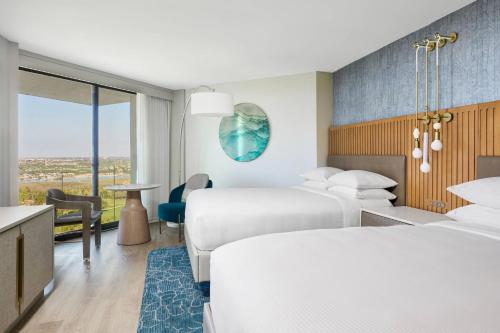 a hotel room with two beds and a desk at VEA Newport Beach, a Marriott Resort & Spa in Newport Beach