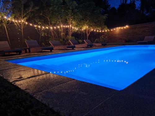 una piscina iluminada por la noche con luces en La Fortunata, en Maldonado