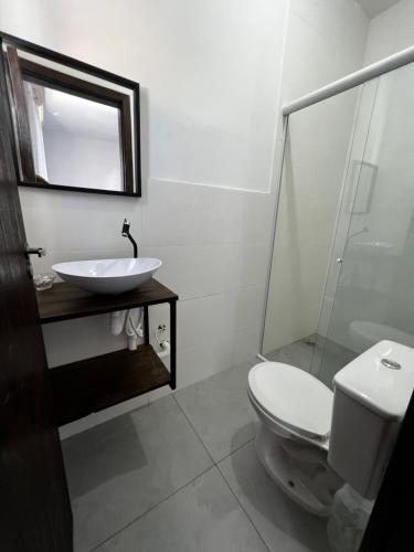 a bathroom with a toilet and a sink and a mirror at Pousada tamatoa in Florianópolis